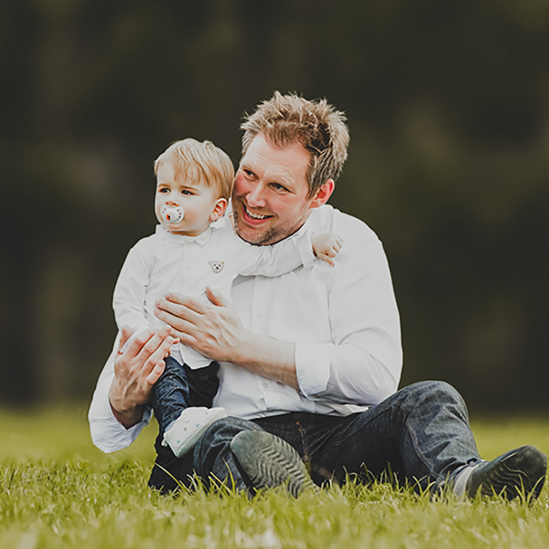 Vater und Sohn gemeinsam im Gras, fotografiert von Bildwerk Ansbach.